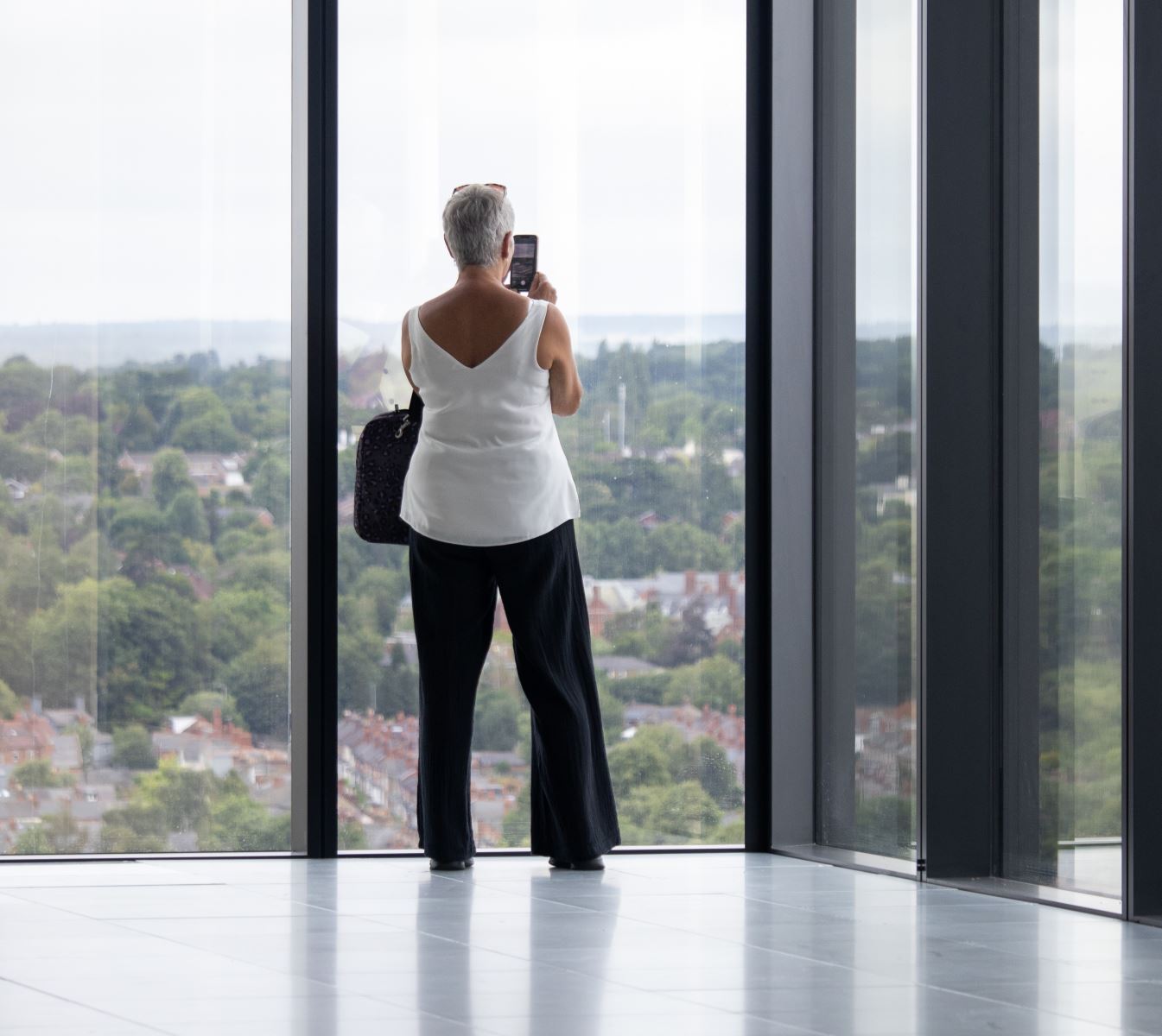 Lady standing next to window looking at view